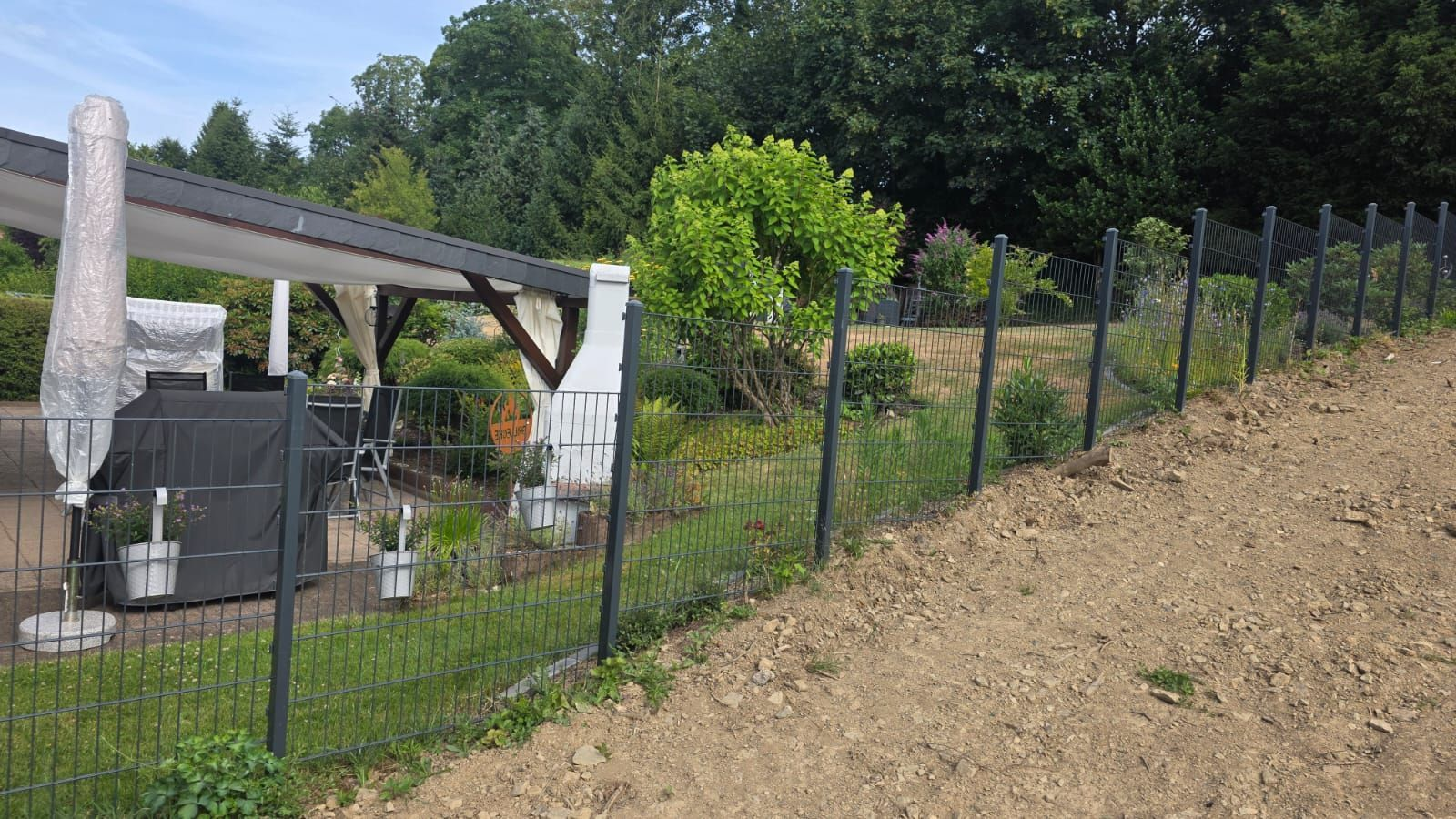 Neu montierter Doppelstabmattenzaun an einem Hanggrundstück